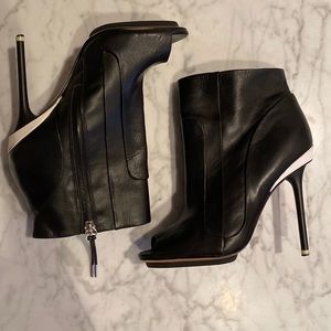 Black stiletto LAMB ankle boot with zipper and white accents
